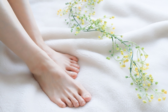 女性の足と花